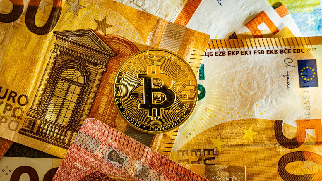 Moneta Bitcoin posata su banconote in euro, conversione da BTC a EUR