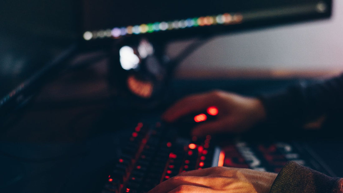Computer e tastiera illuminata in un ambiente scuro, protezione delle chiavi digitali