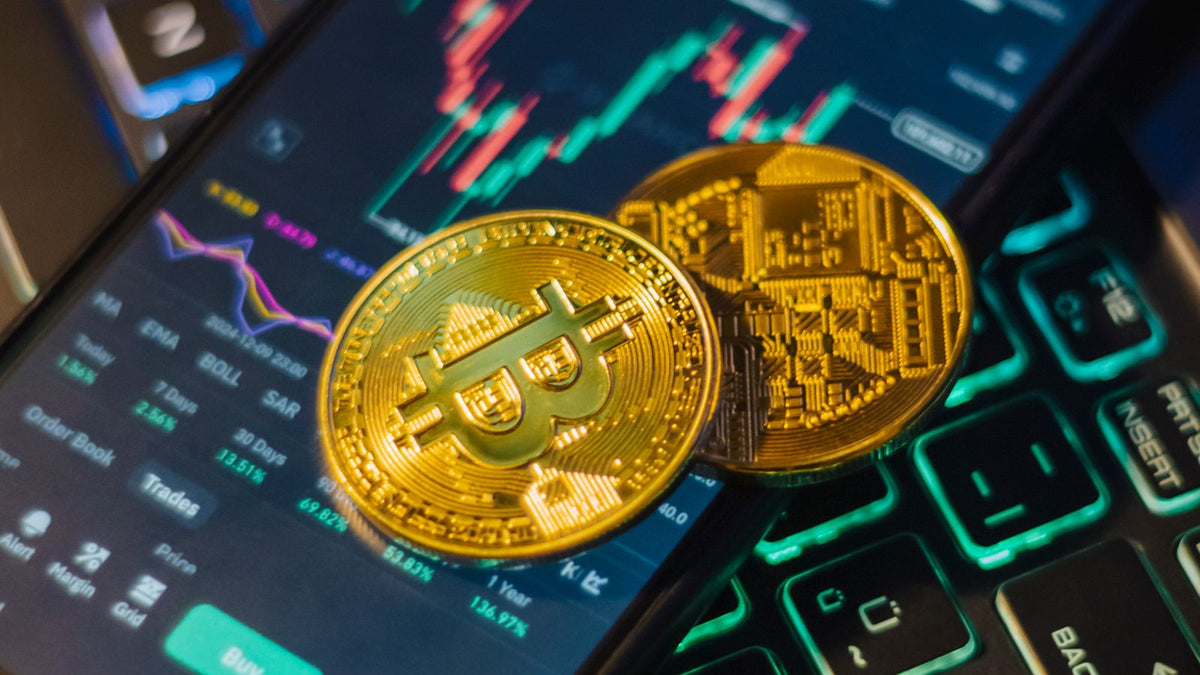 Applicazione di trading di criptovalute su smartphone accanto a monete Bitcoin