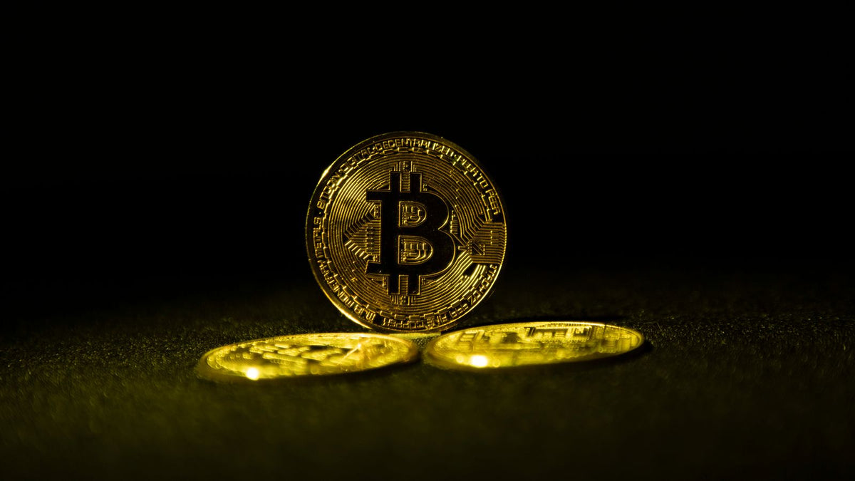 Monete fisiche rappresentative del Bitcoin su sfondo scuro