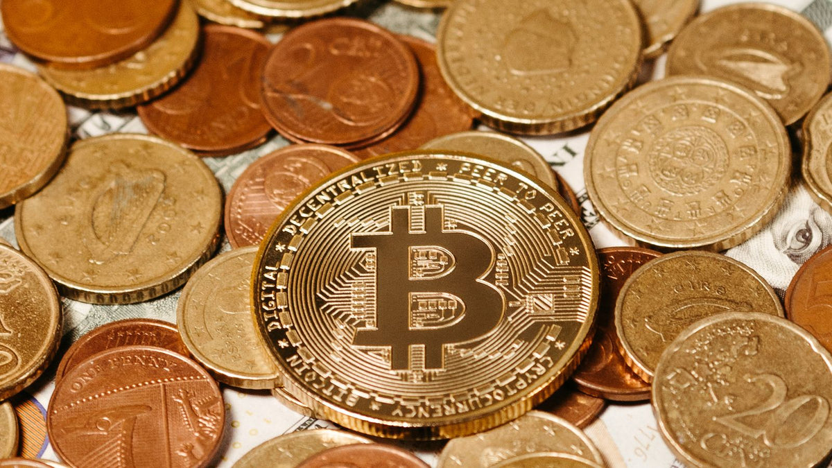 Moneta Bitcoin accanto a monete tradizionali, valutazione di un investimento