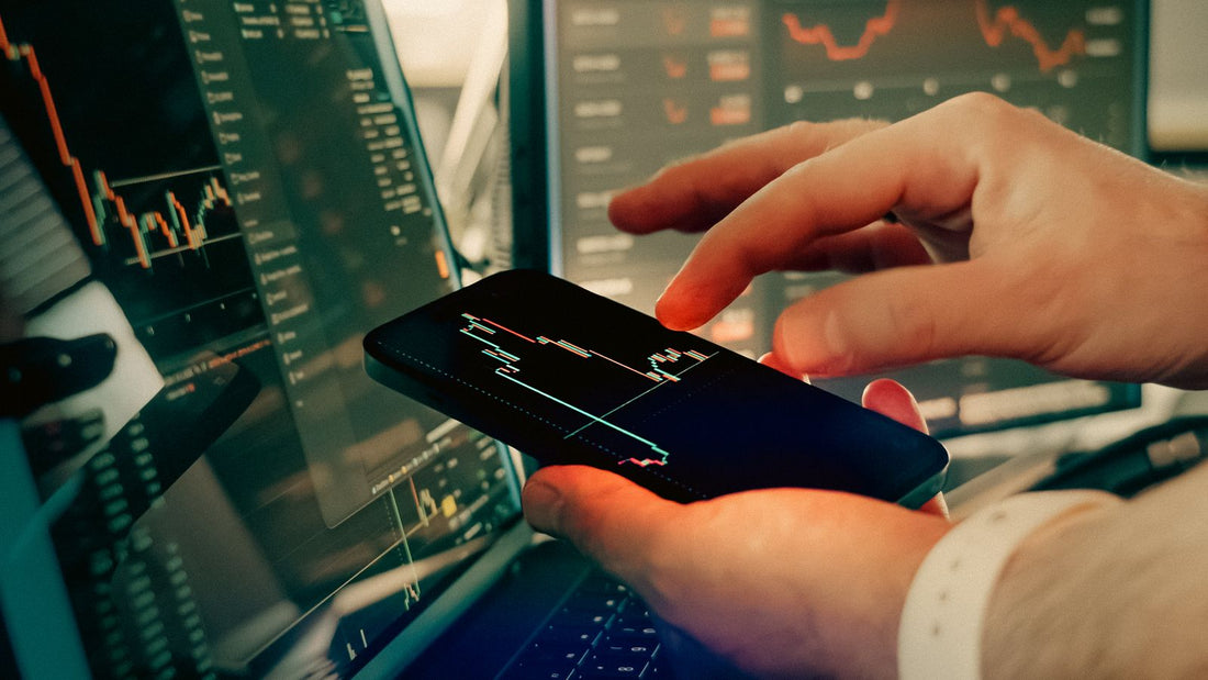 Persona che analizza il mercato delle criptovalute su smartphone e schermi