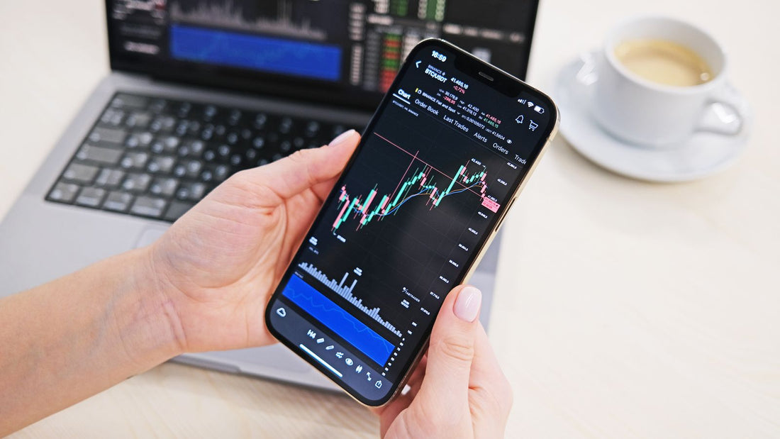 Persona che consulta grafici di trading da smartphone e computer