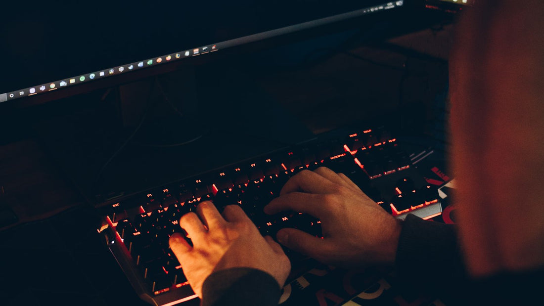 Persona anonima al computer in un ambiente buio, rischi delle frodi online
