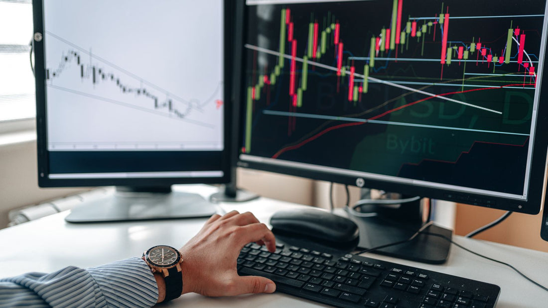 Analista che studia grafici di mercato valutario su due monitor