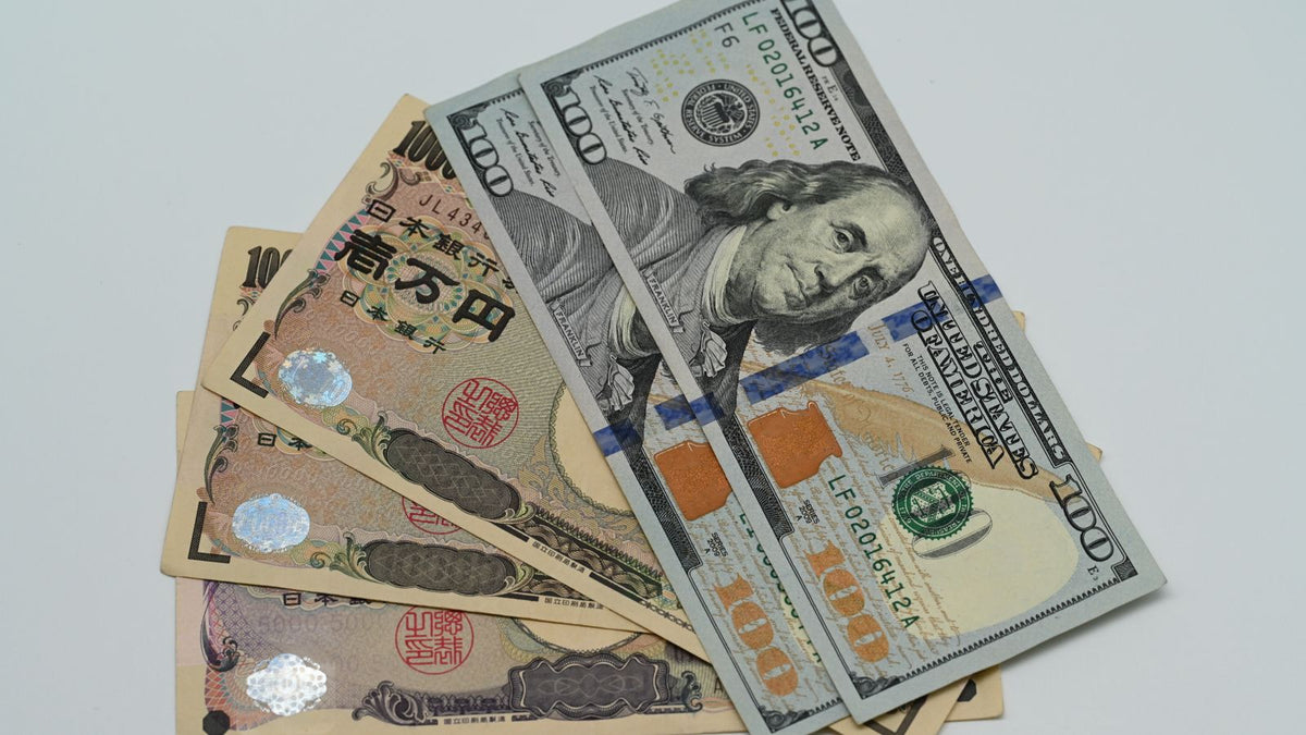 Banconote in dollari USA e yen giapponesi per l'analisi del cambio USD JPY