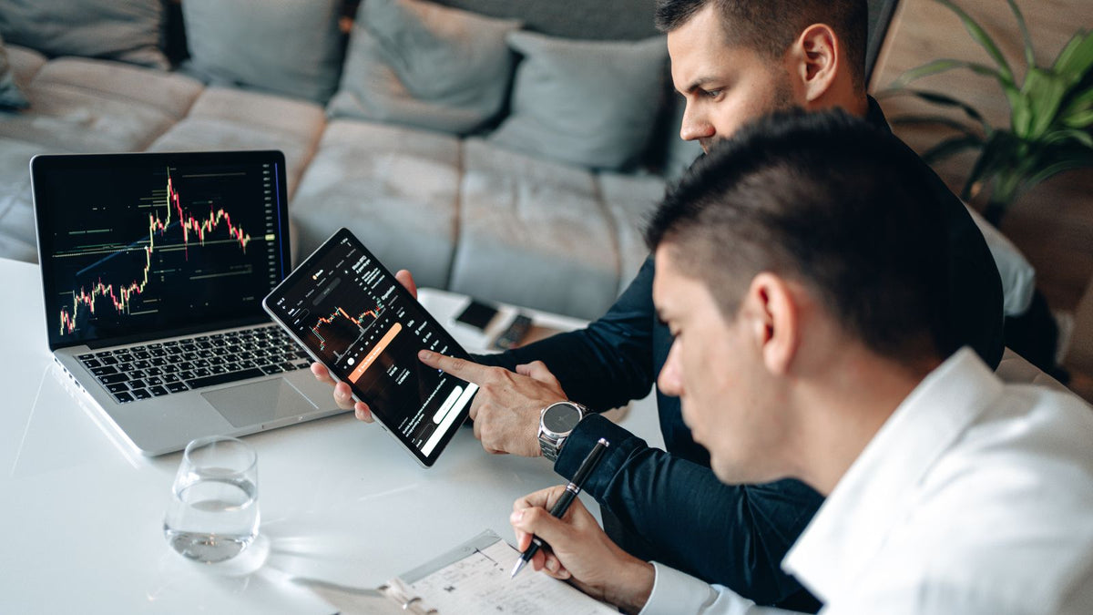 Professionisti che esaminano grafici e documentazione su piattaforme di investimento
