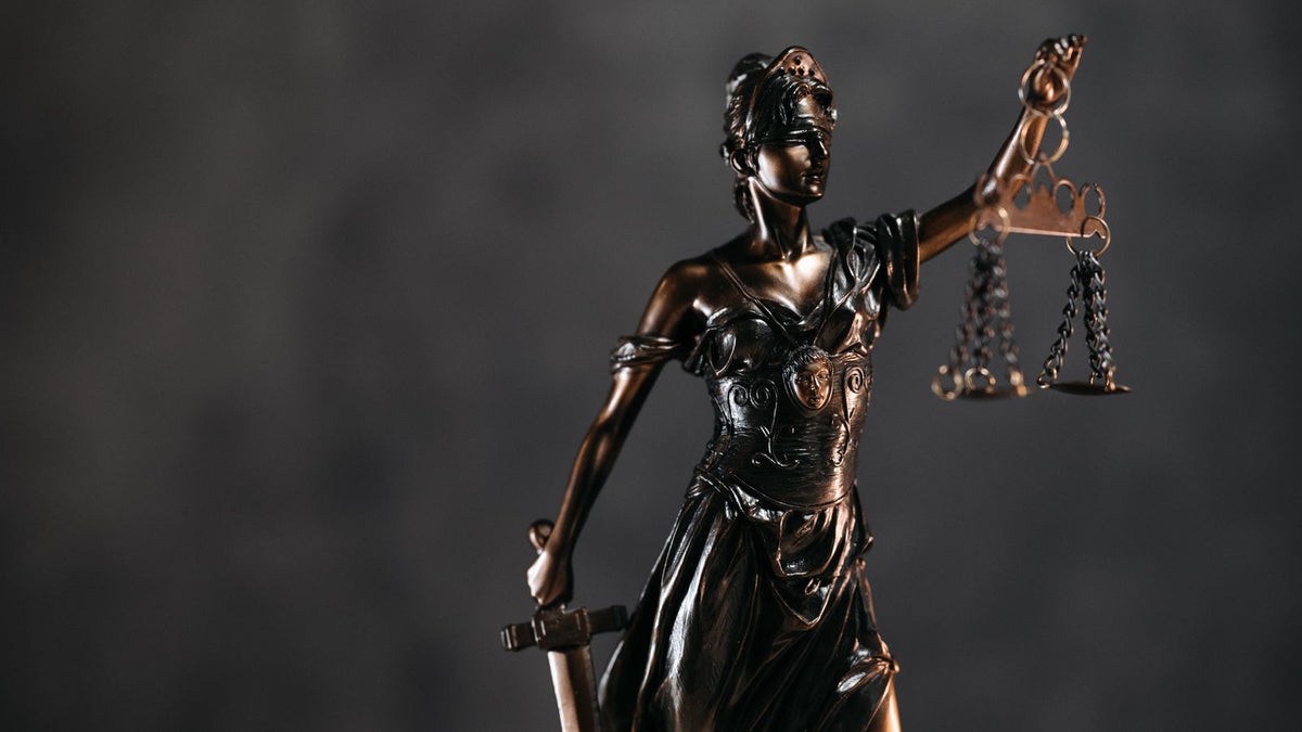 Statua della Giustizia con bilancia, dibattito legislativo sulla regolamentazione crypto