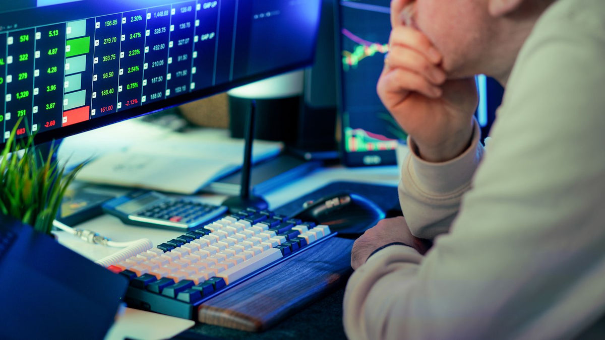 Trader davanti a grafici dei mercati finanziari per spiegare lo spread denaro-lettera