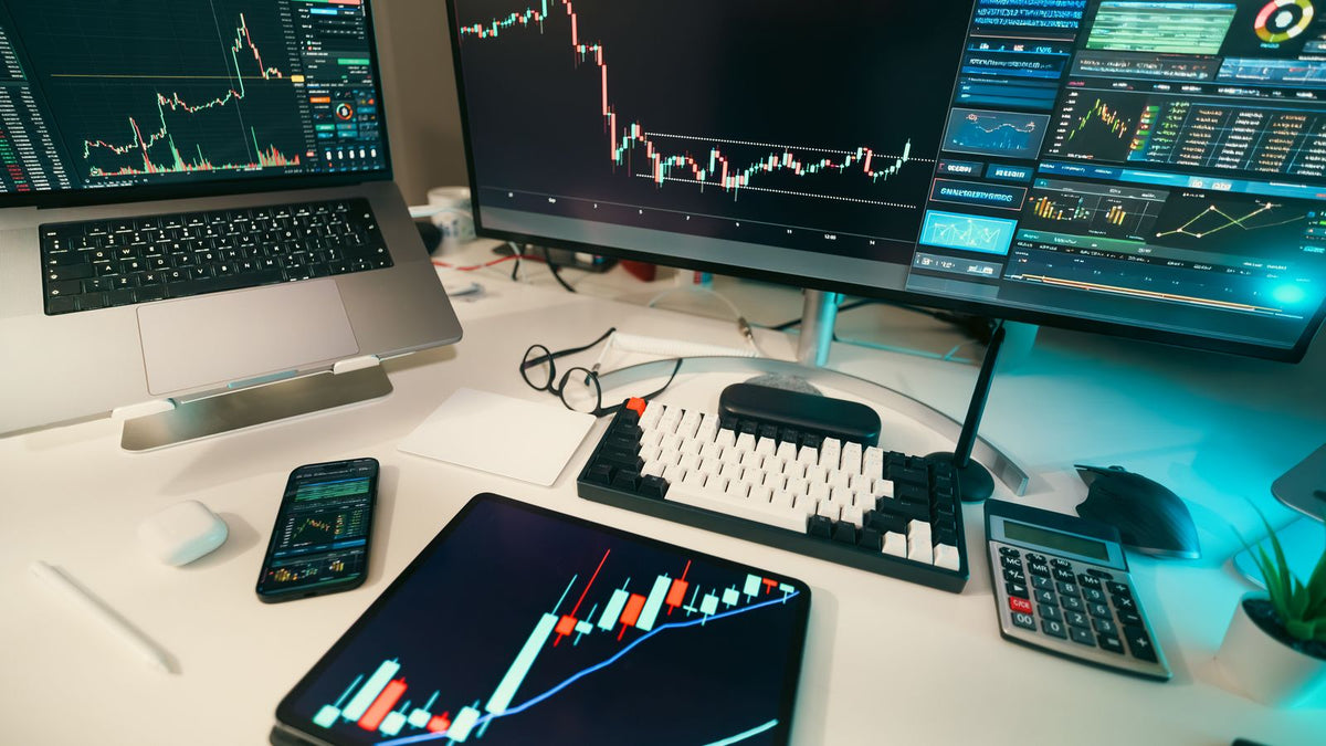 Scrivania di trading con monitor e grafici finanziari per spiegare i contratti CFD