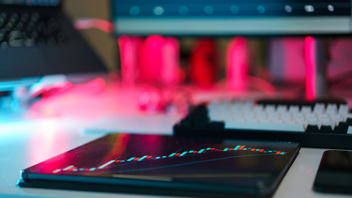 Postazione digitale di analisi dei mercati con grafici su diversi dispositivi, immagine illustrativa di una piattaforma di trading
