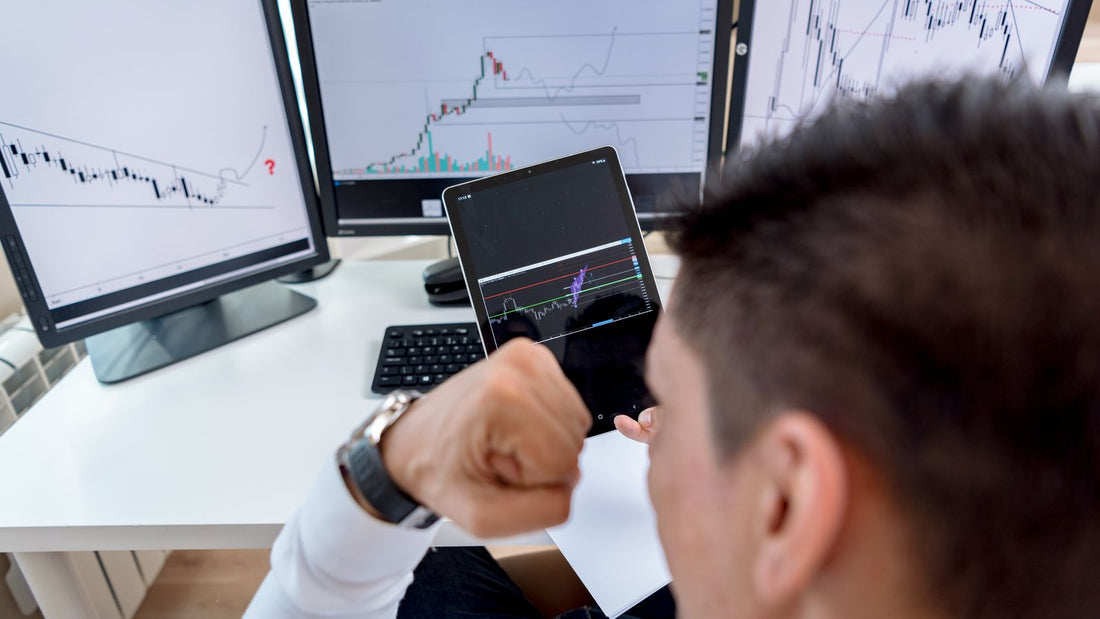 Trader davanti a monitor con grafici dei mercati finanziari per il trading futures