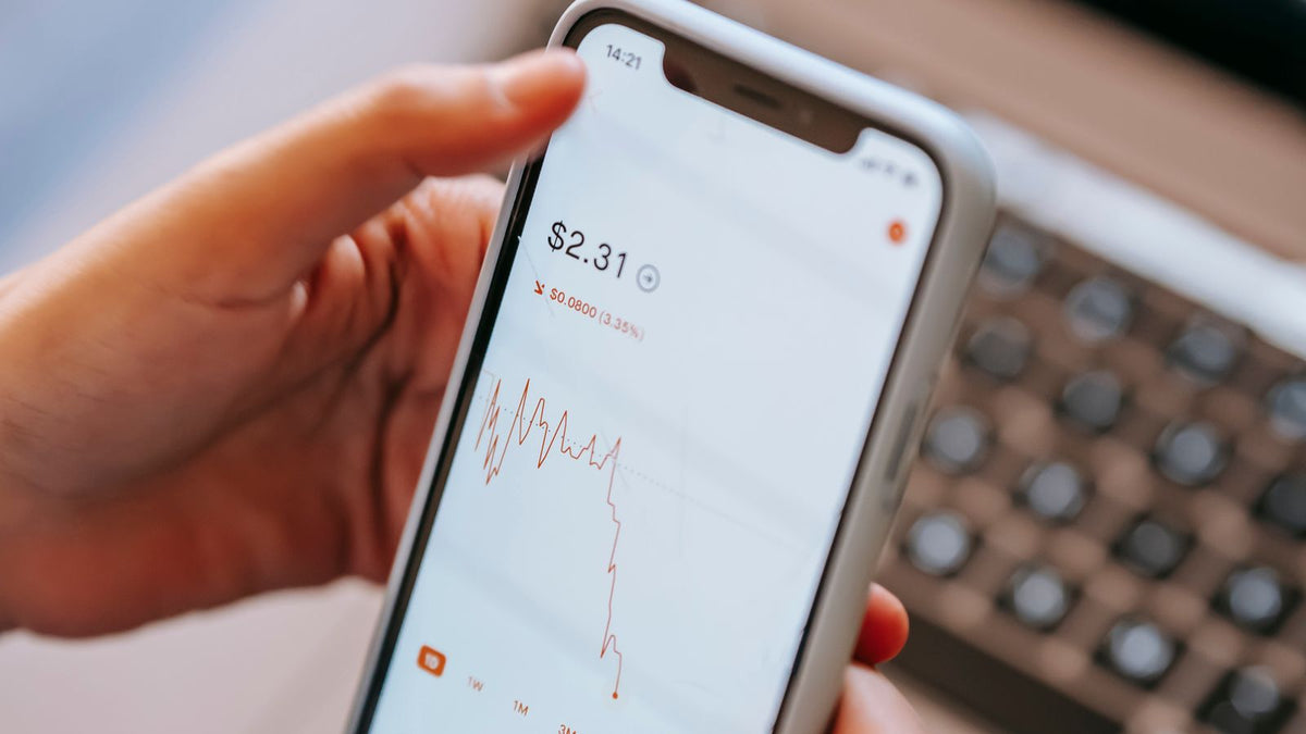 Trader che controlla un'applicazione finanziaria sullo smartphone, rischio delle opzioni binarie