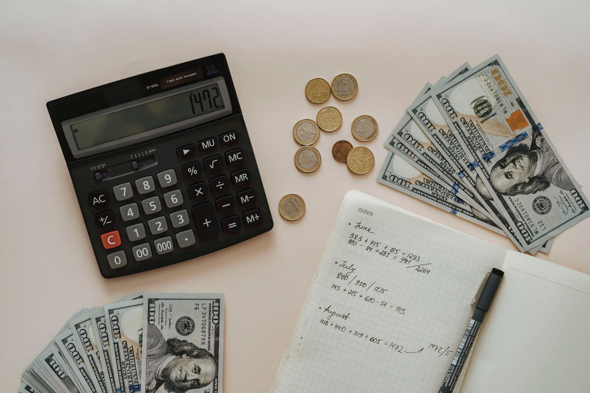 Calcolatrice, denaro e appunti per confrontare risparmio e investimento