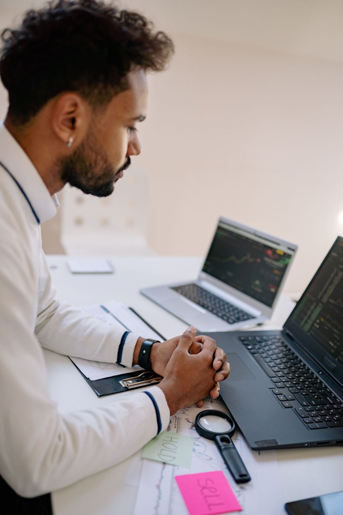 Trader davanti a monitor di borsa e grafici finanziari